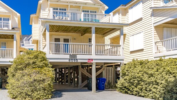 Un hôtel situé en bord de mer, avec une structure à deux étages, un espace extérieur couvert et une enseigne indiquant « Il était une fois, la marée… ».