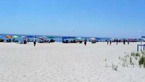 Una playa con gente y sombrillas coloridas.