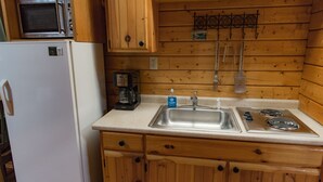A compact kitchen with a refrigerator, microwave, coffee maker, sink, and stove. - Beautiful Romantic River front cabin with mountain views,fantastic location! (Luray)