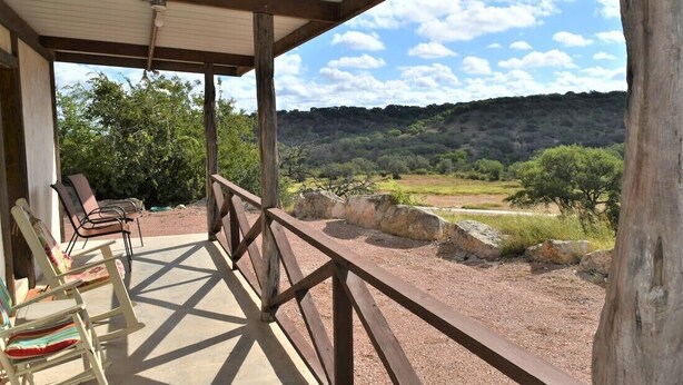 A covered outdoor seating area with chairs and a view of a natural landscape. - Maner Lodge getaway, views from 1 of highest elevation pts, BBQ, 30min FBG (Doss)