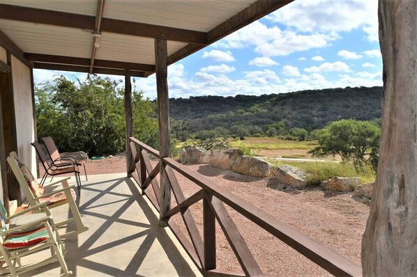 A covered outdoor seating area with chairs and a view of a natural landscape. - Maner Lodge getaway, views from 1 of highest elevation pts, BBQ, 30min FBG (Doss)