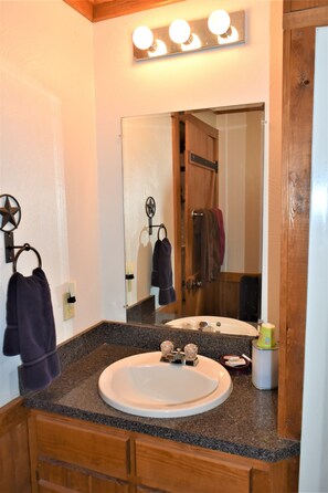 A bathroom with a granite countertop, a white sink, a mirror, and a towel rack with two towels. - Maner Lodge getaway, views from 1 of highest elevation pts, BBQ, 30min FBG (Doss)