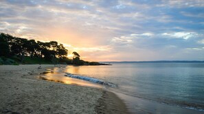 A beach with calm waters, trees, and a sunset. - Seaside Splendour - sleeps 8 (COWES)