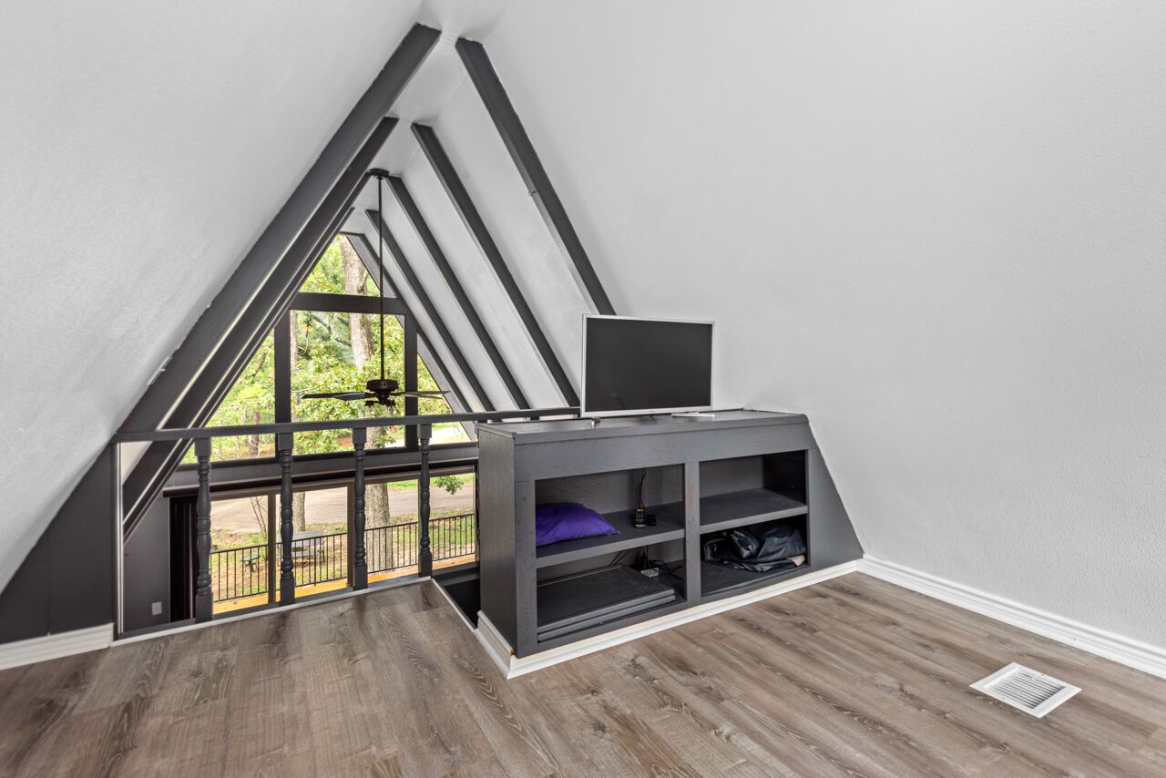 Une pièce avec un plafond en pente, un banc intégré avec espace de rangement et une vue par la fenêtre.