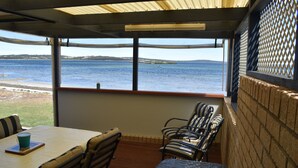 Une pièce avec vue sur la mer, une table avec une tasse et des chaises à rayures.