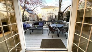 A deck with a table and chairs, a bench, and a view of a house and trees. - Big Kitchen, Two Masters, Hot Tub, Short Walk from Croatan Beach (Virginia Beach)