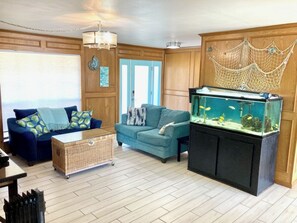 Relax in this stylish living room with a large fish tank, two sofas, and a cozy coffee table.