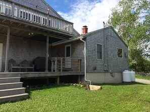 A two-story house with a covered porch, a chimney, and a fenced yard. - Updated, Quiet Location, deck, trees, one bedroom plus futon, Walk To Downtown. (Eastport)