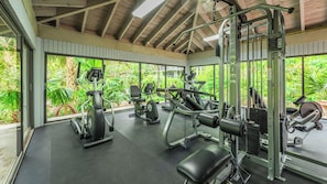 A gym with various exercise equipment, large windows, and a view of greenery. - Henry's Penthouse on the Ocean in Key West  - weekly / nightly rentals (Key West)