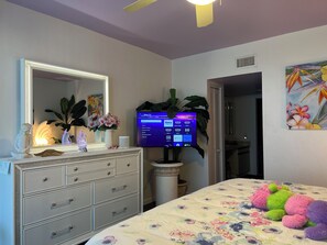 A bedroom with a bed, dresser, mirror, television, and a painting. - Henry's Penthouse on the Ocean in Key West  - weekly / nightly rentals (Key West)