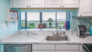 A kitchen with white cabinets, a stainless steel sink, a dishwasher, and a coffee maker. - Sea Colony Oceanfront 1 Bedroom Condo Beautiful View Sept 21 -25 Super Special  (Bethany Beach)
