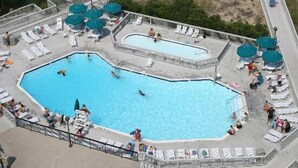 A large outdoor swimming pool with multiple lanes, surrounded by sun loungers and umbrellas. - Sea Colony Oceanfront 1 Bedroom Condo Beautiful View Sept 21 -25 Super Special  (Bethany Beach)