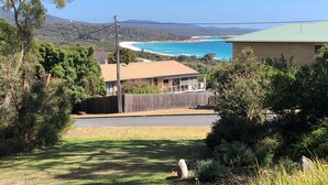 Une maison avec vue sur une plage et l’océan.