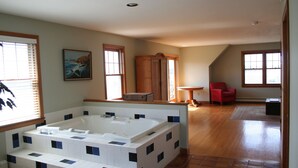 A spacious bathroom with a large bathtub, wooden cabinets, and a red chair in the adjacent room. - Charming 5 bedroom Easton Point colonial with honeymoon suite on 3rd floor (Middletown)