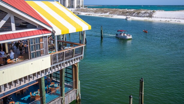 Ein Restaurant am Wasser mit Terrassenplätzen und Blick auf den Strand und den Ozean.