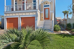 A two-story house with a garage, a balcony, and a well-maintained lawn. - Close to beach! Golf Cart! Private Pool, Gulf Views, Bikes (Miramar Beach)