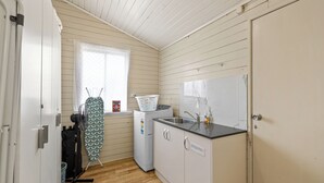 Cocina compacta con lavamanos, lavadora y ventilador.