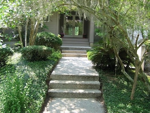 Stroll through lush gardens to the entrance of this traditional building, surrounded by mature trees and beautifully manicured greenery.