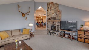 A living room with a stone fireplace, a television, a sofa, and a coffee table. - Private Peninsula With 3,000 Feet Of Lakeshore In The Heart Of Lake Country! (Baxter)