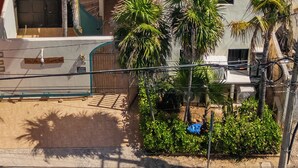 A beachfront property with a pool, a thatched-roof structure, and palm trees. - Villa Tranquila-Versatile 4 Bedroom Villa W/Rooftop Pool, Oceanfront . (Isla Mujeres)