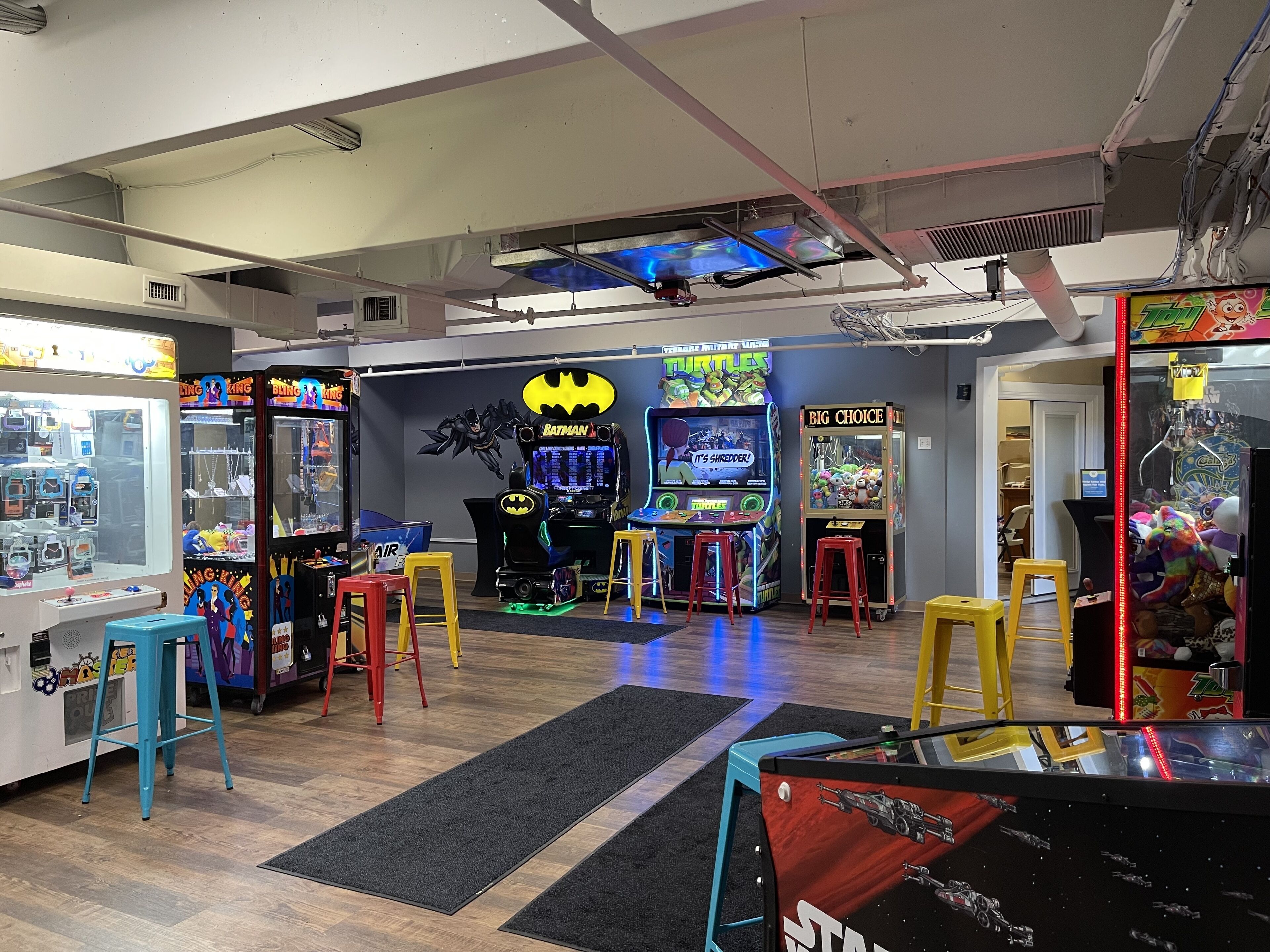 Une salle d’arcade proposant divers jeux, notamment des jeux à l’effigie de Batman et des Tortues Ninja, ainsi qu’un espace sur le thème de Star Wars.