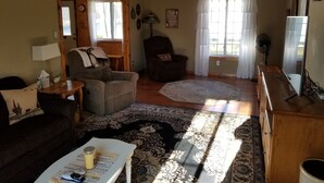 A cozy living room with a sofa, armchair, and a rug. - Beautiful Black Mountain Recreational Area Vacation Rental Cheboygan, MI (Cheboygan)