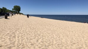A wide sandy beach with a clear blue sky.