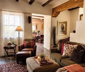 A cozy living room with leather sofas, a coffee table, and a lamp.