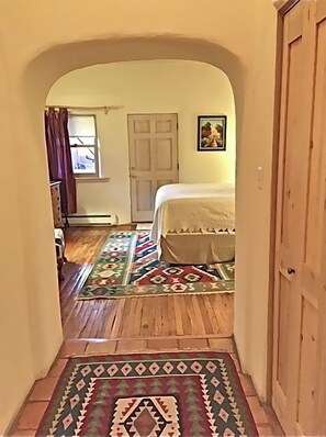 A narrow hallway leading to a bedroom with a bed, a door, and a window. - Beauty and Comfort- Location-Enclosed Patio-Hot Tub - Last  Min.449nt! (Santa Fe)