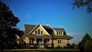 A two-story house with a front porch, a chimney, and a well-maintained lawn.