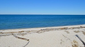 A beach with clear blue water and a sandy shore.
