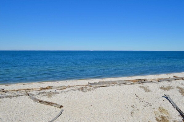 A beach with clear blue water and a sandy shore.