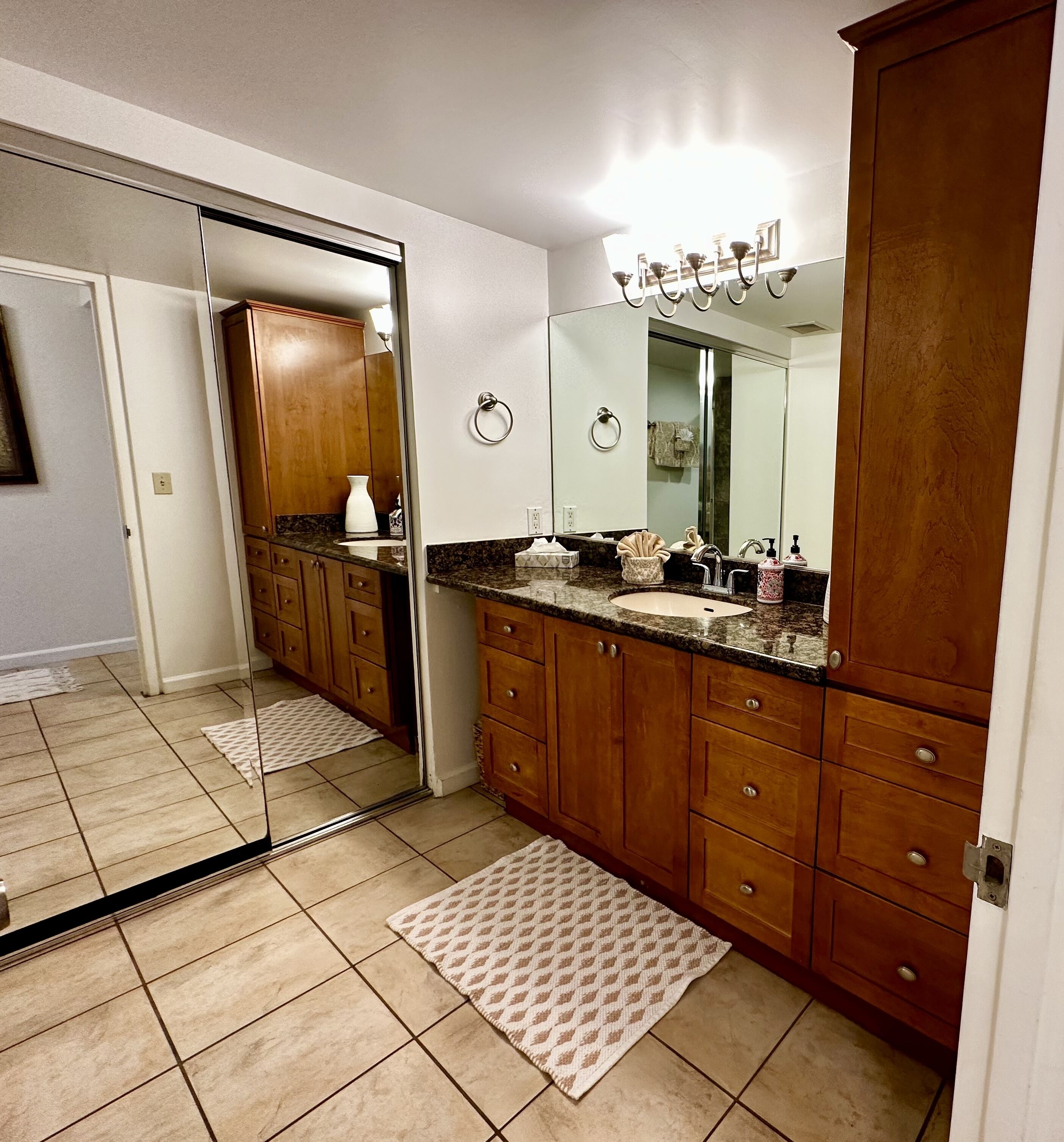 Une salle de bain moderne avec des meubles en bois, un grand miroir, un lavabo et un meuble-vasque.