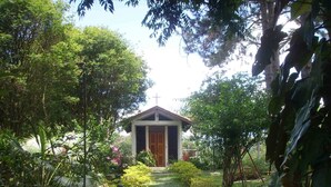 A small chapel surrounded by lush greenery and a stone pathway leading to it. - Mogi das Cruzes Farm - SP. - 90% Atlantic Forest - Cozy!!! (15 people) (Mogi das Cruzes)
