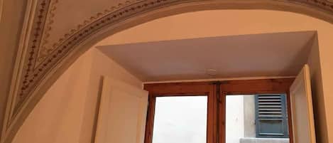 An arched doorway with a decorative ceiling featuring floral patterns.