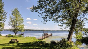 Un espace de pique-nique au bord du lac, avec un banc en bois et une jetée qui s’avance dans l’eau.