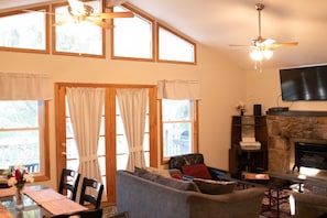 A living room with a fireplace, a television mounted on the wall, and a ceiling fan. - Perfect Getaway In The Poconos! (House #3) HotTub !! Gameroom !! WiFi !! (Albrightsville)