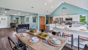 A spacious living area with a dining table set for four, a kitchen with modern appliances, and a cozy seating area with a fireplace. - 4th Nt Free! Waterfront Bungalow! Dock | Kayaks (Wills Point)