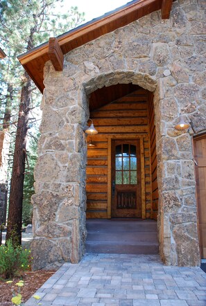 A stone entrance with a wooden door and steps leading to a log cabin interior. - Beautiful Mammoth House  Luxury Home, 4 Bed + Loft/5 Bath-Private Owner (Mammoth Lakes)