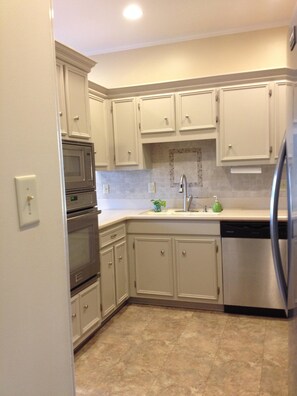 Enjoy cooking in this well-equipped kitchen with a double oven, microwave, dishwasher, and sink.