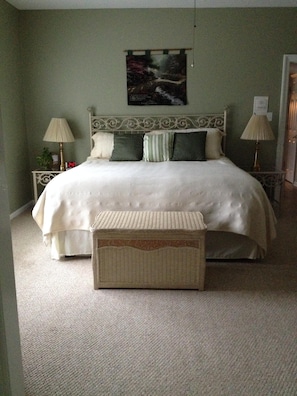 Relax in comfort with a large bed, tufted headboard, and wicker bench.