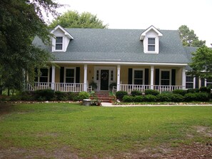 Stunning two-story house with a central entrance and well-manicured lawn.