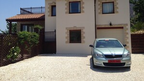 Une maison à deux étages avec une voiture garée devant.