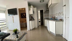 Une cuisine moderne avec des armoires blanches, un four encastré et un dosseret carrelé.