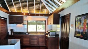 Una cucina compatta con mobili in legno, un forno a microonde integrato e una finestra che permette l'illuminazione naturale.