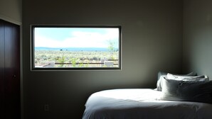 Un dormitorio con un ventanal que ofrece vistas a un paisaje desértico.