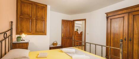 A bedroom with a bed, bedside tables, a wardrobe, and a mirror.