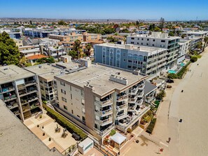 Un hôtel à plusieurs étages doté de balcons, d’un espace piscine et offrant une vue sur la plage.