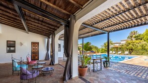 A covered outdoor area with a pool, lounge chairs, and potted plants. - Villa Vale a Pena, for up to 40 people, near Carvoeiro.  (Carvoeiro)