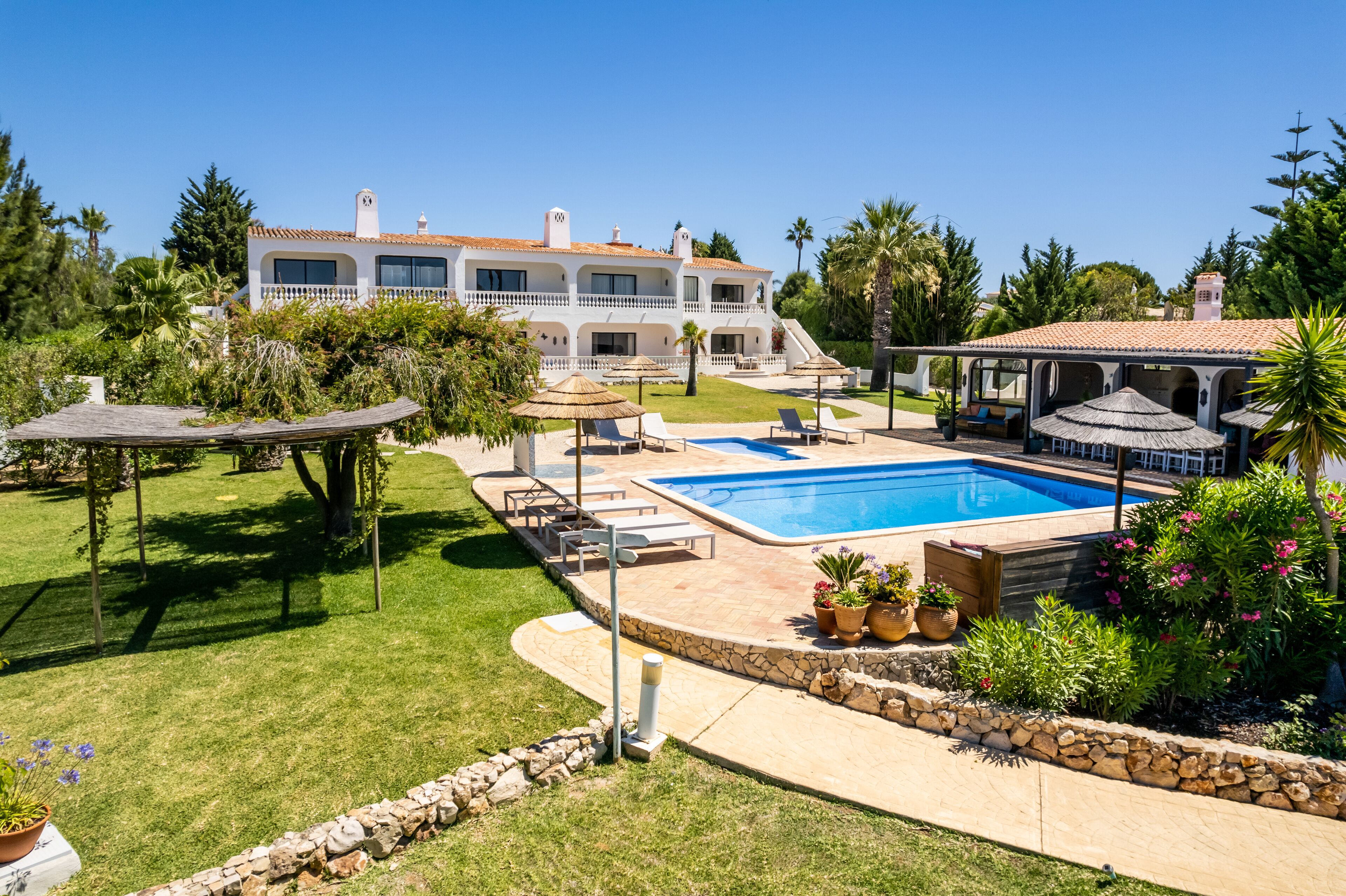 Un'ampia casa con piscina, area relax all'aperto e giardino curato.